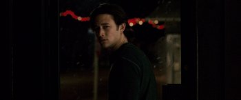 Movie still from “The Lookout” (2007), directed by Scott Frank – A man standing in the dark with lights in the background; Close Up shot, Over the shoulder angle