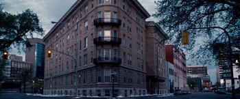 Movie still from “The Lookout” (2007), directed by Scott Frank – A large brick building on the corner of a city street; Extreme Wide shot, Low angle