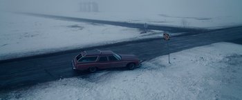 Movie still from “The Lookout” (2007), directed by Scott Frank – A red station wagon driving down a snow covered road; Extreme Wide shot, High angle
