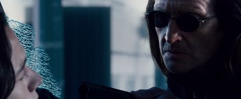 Movie still from “The Lookout” (2007), directed by Scott Frank – A man with long black hair wearing sunglasses; Close Up shot, Over the shoulder angle
