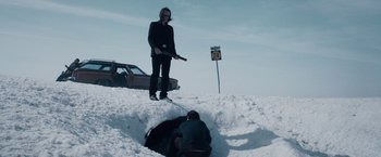 Movie still from “The Lookout” (2007), directed by Scott Frank – A man standing next to a car in the snow; Wide shot, Low angle