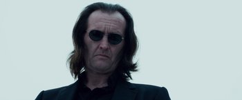 Movie still from “The Lookout” (2007), directed by Scott Frank – A person wearing a suit and sunglasses; Close Up shot, Low angle