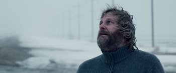 Movie still from “The Lookout” (2007), directed by Scott Frank – A man with a beard looking up into the sky; Close Up shot, Low angle