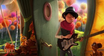 Movie still from “The Lorax” (2012), directed by Chris Renaud – A cartoon of a person playing a guitar; Medium shot, Over the shoulder angle