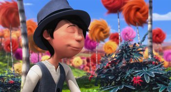 Movie still from “The Lorax” (2012), directed by Chris Renaud – A man in a hat is standing in a field; Medium shot, Low angle