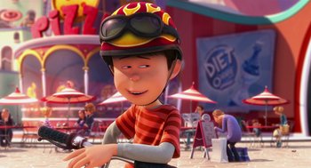 Movie still from “The Lorax” (2012), directed by Chris Renaud – A cartoon of a man with a helmet on sitting on a bike; Close Up shot, Over the shoulder angle