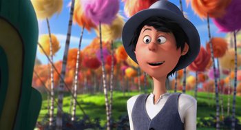Movie still from “The Lorax” (2012), directed by Chris Renaud – A man with a hat is standing in front of trees; Close Up shot, Over the shoulder angle