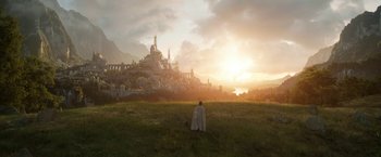 Movie still from “The Lord of the Rings: The Rings of Power” (2022), created by Patrick McKay – A man in a white cape looking out over a city; Extreme Wide shot, Low angle