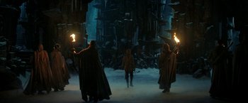 Movie still from “The Lord of the Rings: The Rings of Power” (2022), created by Patrick McKay – A group of people standing in the middle of a dark city; Wide shot, High angle