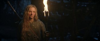 Movie still from “The Lord of the Rings: The Rings of Power” (2022), created by Patrick McKay – A woman holding a burning torch in a dark room; Medium shot, Low angle