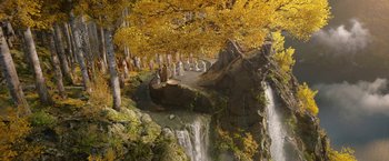 Movie still from “The Lord of the Rings: The Rings of Power” (2022), created by Patrick McKay – Many statues in a forest near a waterfall; Extreme Wide shot, High angle