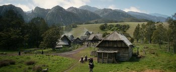 Movie still from “The Lord of the Rings: The Rings of Power” (2022), created by Patrick McKay – A group of people standing on top of a grass covered field; Extreme Wide shot, High angle