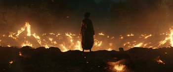 Movie still from “The Lord of the Rings: The Rings of Power” (2022), created by Patrick McKay – A person standing in front of a fire; Extreme Wide shot, High angle