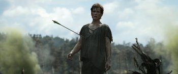 Movie still from “The Lord of the Rings: The Rings of Power” (2022), created by Patrick McKay – A man holding an arrow while standing on a field; Medium shot, Low angle