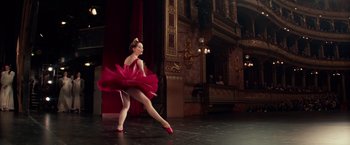 Movie still from “Red Sparrow” (2018), directed by Francis Lawrence – A woman in a red dress is dancing on a stage; Wide shot, Low angle