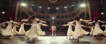 Movie still from “Red Sparrow” (2018), directed by Francis Lawrence – A group of women in white dresses dancing in a theater; Wide shot, Low angle
