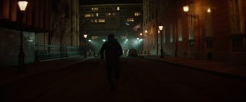 Movie still from “Red Sparrow” (2018), directed by Francis Lawrence – A person walking down a street at night; Wide shot, Low angle