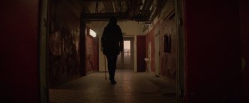 Movie still from “Red Sparrow” (2018), directed by Francis Lawrence – A person walking down a hallway with a cane; Wide shot, Low angle