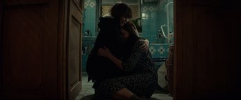 Movie still from “Red Sparrow” (2018), directed by Francis Lawrence – Two women hugging in a bathroom with blue tiled walls; Wide shot, High angle