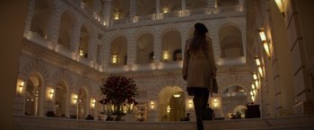 Movie still from “Red Sparrow” (2018), directed by Francis Lawrence – A woman standing in front of a large building; Wide shot, Low angle