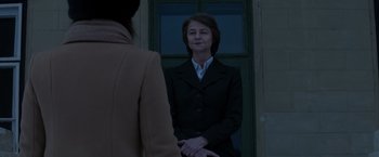 Movie still from “Red Sparrow” (2018), directed by Francis Lawrence – A woman standing in front of another woman in front of a building; Medium shot, Over the shoulder angle