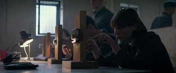 Movie still from “Red Sparrow” (2018), directed by Francis Lawrence – A group of people sitting at a table; Medium shot, Low angle