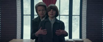 Movie still from “Red Sparrow” (2018), directed by Francis Lawrence – A woman standing next to another woman in front of a window; Medium shot, Low angle