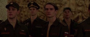 Movie still from “Red Sparrow” (2018), directed by Francis Lawrence – A group of men standing next to each other in military uniforms; Medium shot, Low angle