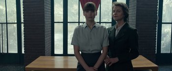 Movie still from “Red Sparrow” (2018), directed by Francis Lawrence – Two women standing next to each other in front of a window; Medium shot, Low angle