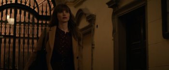 Movie still from “Red Sparrow” (2018), directed by Francis Lawrence – A woman standing in front of an archway looking to her left; Medium shot, Over the shoulder angle