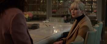 Movie still from “Red Sparrow” (2018), directed by Francis Lawrence – A woman sitting at a table in front of a counter; Medium shot, Over the shoulder angle