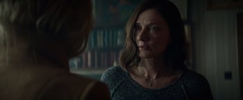 Movie still from “Red Sparrow” (2018), directed by Francis Lawrence – A woman in a grey sweater talking to another woman in front of a book shelf; Close Up shot, Over the shoulder angle