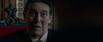 Movie still from “Red Sparrow” (2018), directed by Francis Lawrence – An older man wearing a suit and tie looking at the camera; Close Up shot, Low angle