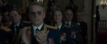 Movie still from “Red Sparrow” (2018), directed by Francis Lawrence – A man and a woman in military uniforms clapping; Medium shot, Over the shoulder angle