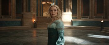 Movie still from “The Lord of the Rings: The Rings of Power” (2022), created by Patrick McKay – A woman standing in front of a staircase in a room; Medium shot, Over the shoulder angle