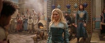 Movie still from “The Lord of the Rings: The Rings of Power” (2022), created by Patrick McKay – A beautiful blonde woman wearing a blue dress; Medium shot, Over the shoulder angle