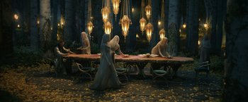 Movie still from “The Lord of the Rings: The Rings of Power” (2022), created by Patrick McKay – A group of people sitting at a table in front of a mirror; Wide shot, High angle