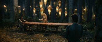 Movie still from “The Lord of the Rings: The Rings of Power” (2022), created by Patrick McKay – A woman standing in front of a long wooden table; Wide shot, Over the shoulder angle