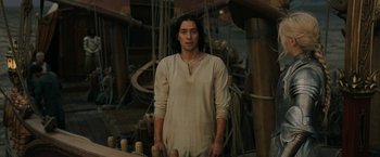 Movie still from “The Lord of the Rings: The Rings of Power” (2022), created by Patrick McKay – A man standing on a boat in the middle of the ocean; Medium shot, High angle