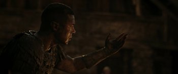 A man in a dark room with his hand outstretched