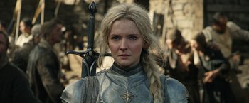 Movie still from “The Lord of the Rings: The Rings of Power” (2022), created by Patrick McKay – A person holding a sword and wearing armor; Close Up shot, Over the shoulder angle