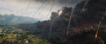 Movie still from “The Lord of the Rings: The Rings of Power” (2022), created by Patrick McKay – An aerial view of a bunch of smoke coming out of the sky; Extreme Wide shot, High angle