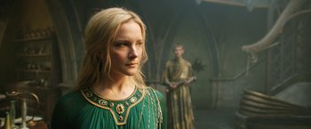 Movie still from “The Lord of the Rings: The Rings of Power” (2022), created by Patrick McKay – A woman in a green dress standing next to a man; Close Up shot, Low angle