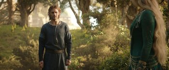 Movie still from “The Lord of the Rings: The Rings of Power” (2022), created by Patrick McKay – A man standing in the middle of a forest; Medium shot, Low angle