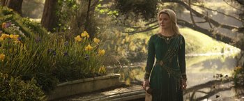 Movie still from “The Lord of the Rings: The Rings of Power” (2022), created by Patrick McKay – A woman in a green dress standing next to a pond; Medium shot, Low angle