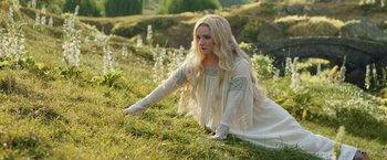 Movie still from “The Lord of the Rings: The Rings of Power” (2022), created by Patrick McKay – A woman in a white dress sitting on the grass; Medium shot, High angle