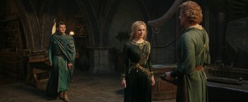Movie still from “The Lord of the Rings: The Rings of Power” (2022), created by Patrick McKay – A woman in a green dress standing next to a man; Wide shot, Over the shoulder angle