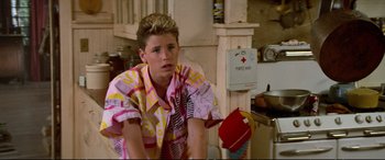 Movie still from “The Lost Boys” (1987), directed by Joel Schumacher – A young man sitting in front of a fire hydrant; Medium shot, Low angle