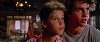 Movie still from “The Lost Boys” (1987), directed by Joel Schumacher – A young man with blue eyes and blonde hair; Close Up shot, Low angle