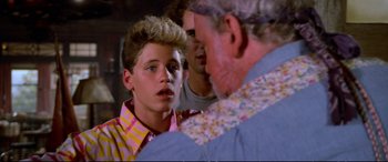 Movie still from “The Lost Boys” (1987), directed by Joel Schumacher – A group of young men standing next to each other in a room; Close Up shot, Over the shoulder angle